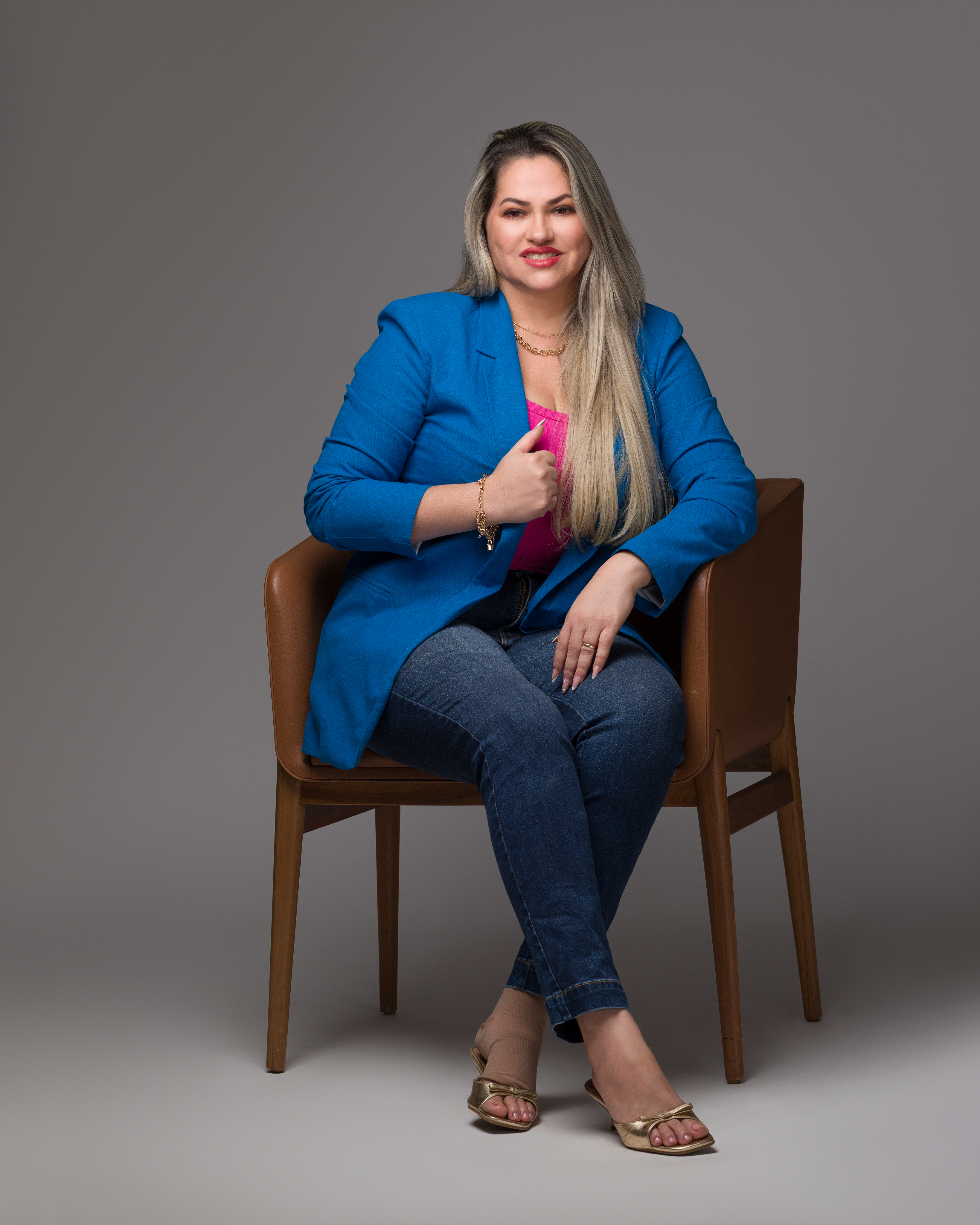 Dra. Jucimeire sentada em poltrona azul